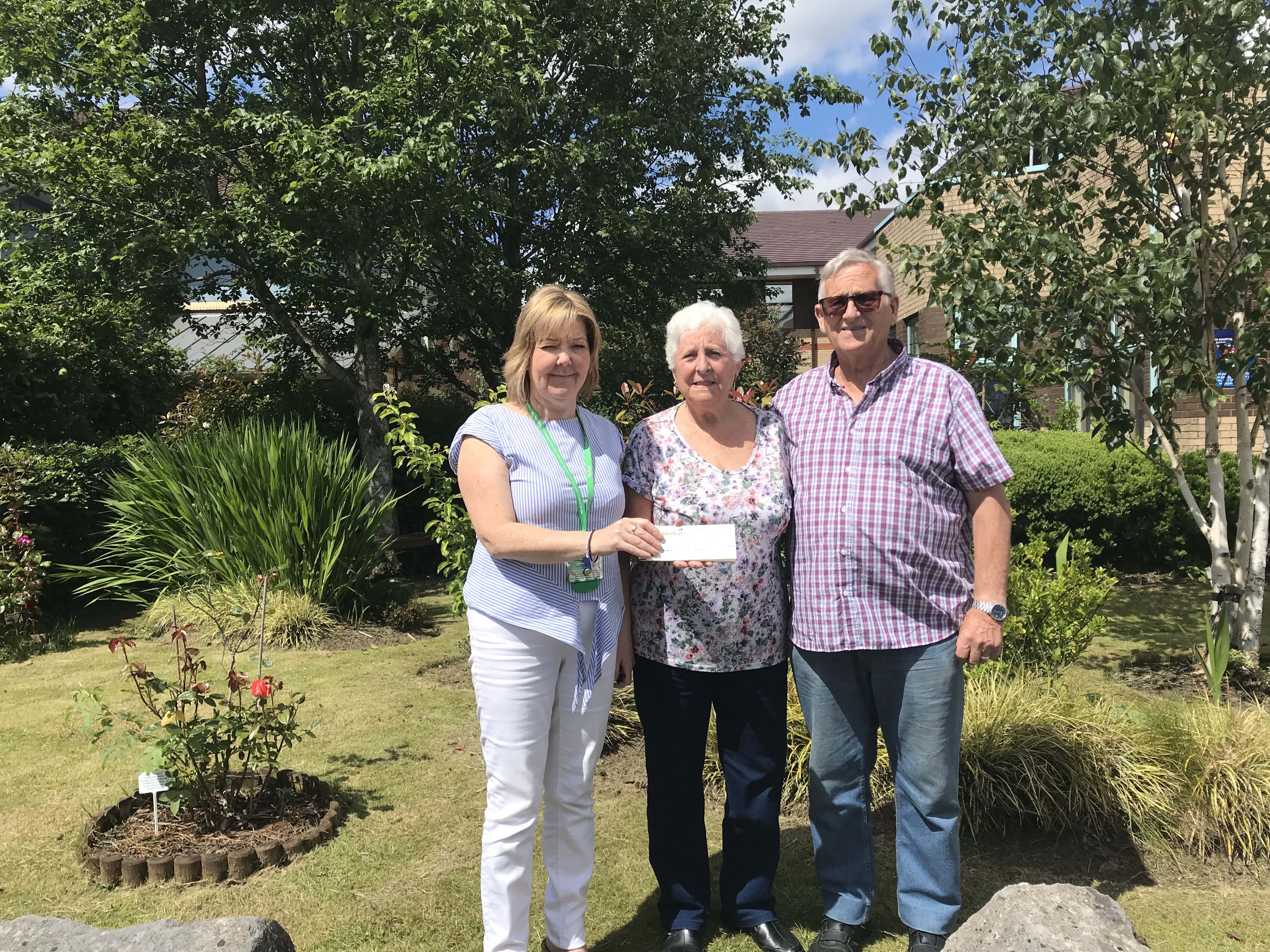 Macmillan benefits advisor Shirley Melly given a cheque from Tony and his wife Christine